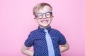 Portrait of a little smiling boy in a funny glasses and tie. School. Preschool. Fashion. Studio portrait over pink background Royalty Free Stock Photo