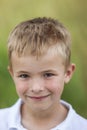 Portrait of a little smiling boy with golden blonde straw hair i Royalty Free Stock Photo