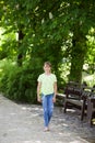 Portrait of little smiling girl child walking outdoor in park at sunny day in spring. Blooming chestnut tree in the background. Royalty Free Stock Photo