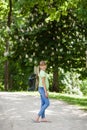 Portrait of little smiling girl child walking outdoor in park at sunny day in spring. Blooming chestnut tree in the background. Royalty Free Stock Photo