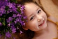 Portrait of a little smyling girl lying near flowers, summer feeling concept