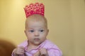 Portrait of a little three-month-old girl in a crown