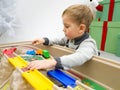 Closeup portrait of little toddler boy playing with toy trains and tracks Royalty Free Stock Photo