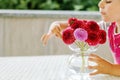 Portrait of little toddler girl admiring bouquet of blooming red and pink dahlia flowers. Cute happy child smelling and Royalty Free Stock Photo