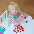 Portrait of little toddler girl painting with brush