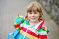 Portrait of little toddler girl on rainy day. Happy positive child running through rain, puddles. Preschool kid with Royalty Free Stock Photo