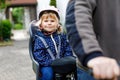 Portrait of little toddler girl with security helmet on the head sitting in bike seat and her father with bicycle. Safe Royalty Free Stock Photo