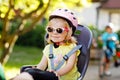 Portrait of little toddler girl with security helmet on the head sitting in bike seat of parents. Boy on bicycle on Royalty Free Stock Photo