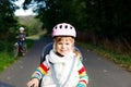 Portrait of little toddler girl with security helmet on the head sitting in bike seat of parents. Boy on bicycle on Royalty Free Stock Photo