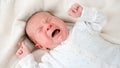 Portrait of little 2 weeks old baby boy crying in baby crib or bed Royalty Free Stock Photo