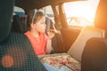 Portrait of little 5 YO girl eating just cooked Italian pizza sitting in child car seat on car back seat and looking out window . Royalty Free Stock Photo
