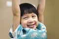 Portrait of lively Boy arm raised with smiling face and eating meal.