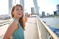 Portrait of lively girl turns around and smile to the camera with modern cityscape on the background, Rotterdam, Netherlands