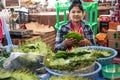 Yangon, Myanmar - December 31 2019: A local woman sells paan chewing tobacco with betel vine leaves and areca nut