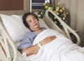 Lonely Asian senior  woman lying in hospital bed, looking up and thinking. Elderly health concept Royalty Free Stock Photo