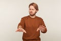 Portrait of lonely blind disabled man with beard wearing sweatshirt standing with closed eyes and outstretched hands