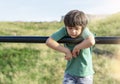 Portrait of lonely child standing alone in playground, Sad boy playing alone at the park,Poor kid with thinking face looking down Royalty Free Stock Photo