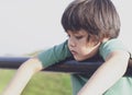 Portrait of lonely child standing alone in playground, Sad boy playing alone at the park,Poor kid with thinking face looking out w Royalty Free Stock Photo