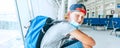 Portrait of lonely teen solo traveler with a backpack in empty airport passenger transfer hall in protective face mask and sadly Royalty Free Stock Photo