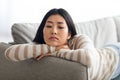 Portrait Of Lonely Upset Young Asian Female Lying On Couch At Home