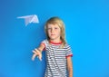 Portrait of long hair cute boy throwing paper plane Royalty Free Stock Photo
