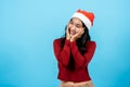 portrait, Long-haired asian girl red long-sleeved top wearing christmas hats, bring both hands her cheeks, making heart Royalty Free Stock Photo