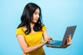 portrait, long haired girl wearing shirt yellow tights, In hand holds laptop computer, other hand used to press keyboard, Royalty Free Stock Photo