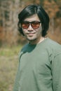 Portrait of long hiar asian man with smiling face standing outdoor