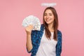 Portrait of lottery winner, lucky angelic girl with halo over head showing money, holding dollar bills