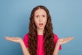 Portrait of lovely adorable reliable speechless girl hands hold empty space on blue background