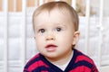 Portrait of lovely baby boy age of 1 year against white bed Royalty Free Stock Photo