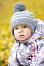 Portrait of lovely baby boy outdoors in autumn against yellow le