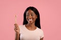 Portrait of lovely black lady with shiny smile holding eco toothbrush with paste over pink studio background Royalty Free Stock Photo