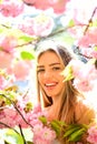 Portrait of lovely blond girl surrounded by pink petals. Female with big eyes and charming smile on natural background Royalty Free Stock Photo