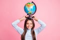 Portrait of lovely cheerful smart funny girl carrying globe on head lesson isolated over pink pastel color background Royalty Free Stock Photo