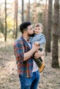 Portrait of lovely family, father and little kid son, walking together in pine forest in autumn. Happy handsome bearded Royalty Free Stock Photo