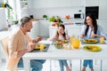 Portrait of lovely friendly family sit kitchen table enjoy tasty homemade food communicate joking morning apartment Royalty Free Stock Photo