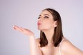 Portrait of lovely girl kissing you isolated on studio background. Pretty woman sends an air kiss. Pretty girl makes air Royalty Free Stock Photo