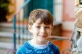 Portrait of lovely gorgeos school kid boy sitting infront of house. Happy healthy boy on stairs by home.