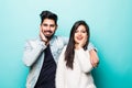 Portrait of happy lovely indian couple smiling and posing on camera while pleasend signs together over green background Royalty Free Stock Photo