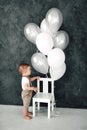 Portrait of lovely little boy happy smiling celebrating 1 year birthday. One year old european boy sitting on floor Royalty Free Stock Photo