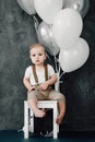 Portrait of lovely little boy happy smiling celebrating 1 year birthday. One year old european boy sitting on floor Royalty Free Stock Photo