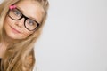 Portrait of a lovely little girl daughter in long blond hair and black glasses with pink bow Royalty Free Stock Photo