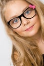 Portrait of a lovely little girl daughter in long blond hair and black glasses with pink bow Royalty Free Stock Photo