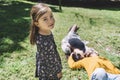 Portrait of a lovely little girl looking camera while her parents laying on ground in a sunny day at park Royalty Free Stock Photo