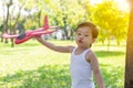 Portrait lovely little handsome boy. Attractive handsome child is playing toy airplane at park. Cute kid is imagining that he is