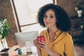 Portrait of lovely peaceful entrepreneur lady arms hold fresh coffee cup good mood loft interior business center inside