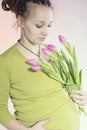 Portrait of lovely pregnant woman with tulips