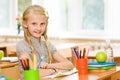 Portrait of lovely schoolgirl in classroom. looking at camera