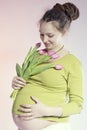 Portrait of lovely smiling pregnant woman with tulips